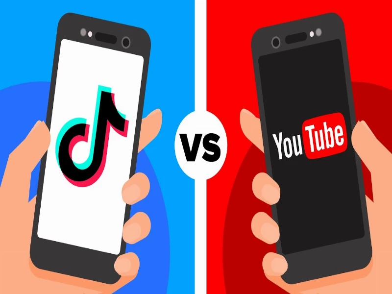 image showing two hands holding 2 phones. one phone has the tiktok logo and the other has youtube logo with VS sign in the middle.