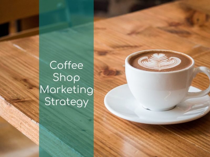 Coffee cup on a coffee shop table with the words Coffee Shop Marketing Strategy