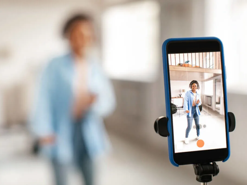 Realtor recording social media video outside a residential property using a smartphone